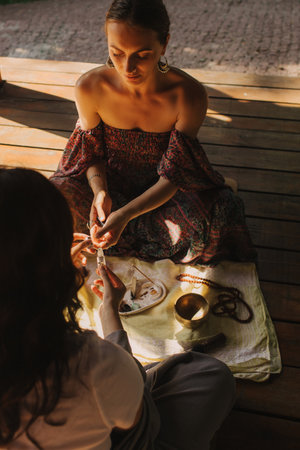 Close up of a mindful meditation and wellness session in a gazebo. Facilitating meditative experience with singing bowl. Soft focus, warm lighting effectの写真素材