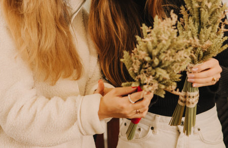 Close up of female hands hold Didukh. Master class on making Ukrainian Christmas decoration and traditional symbol. Made of straw of different cereals. Didukh literally means the spirit of ancestorsの写真素材