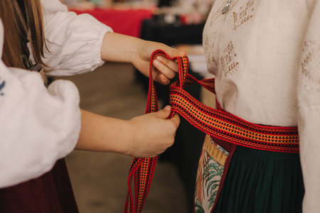 Part of Ukrainian traditional national costume closeup: embroidered shirt, vyshyvanka, skirt, woven belt. Culture of Ukraine. Part of a seriesの写真素材