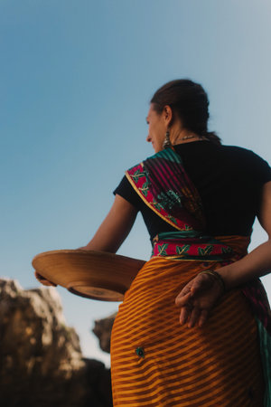 Indian woman in traditional saree clothes on the nature with the ocean on background. Indian...