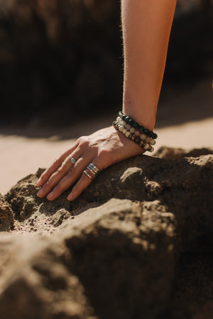 Close up of woman's hands in traditional jewelry on the nature. Festival costume. Concept of solo tourism and travel. Part of a seriesの写真素材