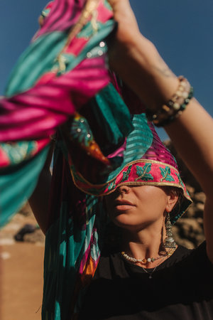 Close-up portrait of Indian woman in traditional clothes dancing on the nature with the ocean on background. Indian festival costume. Concept of solo tourism and travel to India. Part of a seriesの写真素材