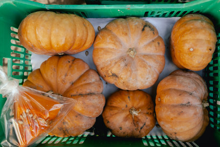 Close up of miniature pumpkins in a plastic box at a local market. Shopping at a farmers market....