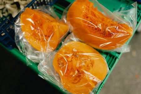 Close-up of fresh pumpkins, cut into pieces and packed in a plastic bag. Shopping at the farmers market. Close-up. Part of a seriesの写真素材