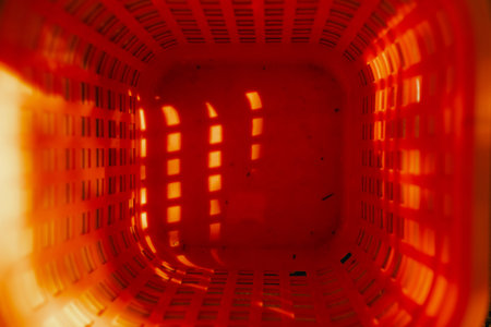 Top view of plastic orange shopping basket at local urban market. Organic produce on sale at outdoor farmer market. Close up. Part of the series.の写真素材