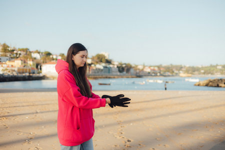 Close-up of ecologist volunteer's hands cleans the beach on the seashore from plastic and other waste. Garbage recycle and environmental care concept. Part of a seriesの写真素材