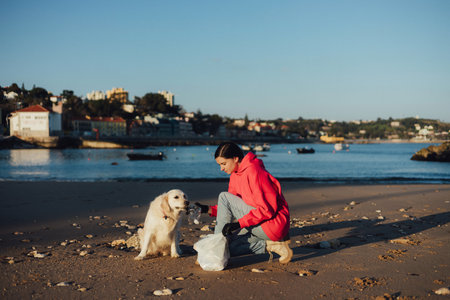 A female ecologist volunteer cleans the beach on the seashore from plastic and other waste. Garbage recycle and environmental care concept. Part of a seriesの写真素材
