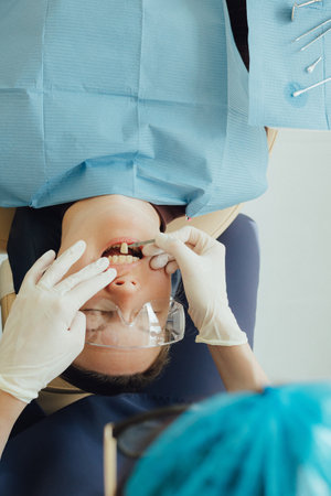 Smiling mature woman at dental check-up with young female dentist. Appointment at clinic. Tooth...