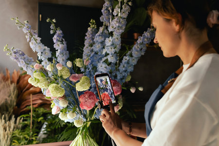 Small flower shop. A woman writes a video blog or online course. Flower school concept. Florist...