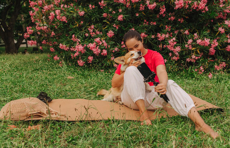 Young girl with Corgi recording video on phone share via app her travel vacation. Gen Z influencer shooting social media stories. Concept of friendship between a dog and human. Part of a series. UGCの写真素材