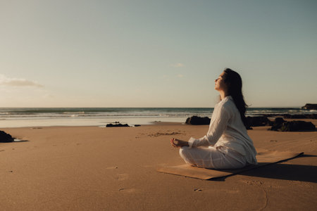 Asian woman in white clothes practice yoga for meditation and relaxation for healthy near seaside. Healthcare exercise and yoga concept. Solo tourism. Part of a series.の写真素材