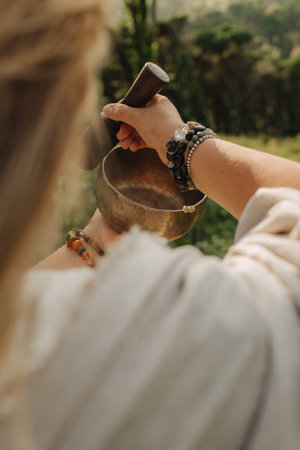 Close-up of female hands holding sound healing instruments. Tools for therapy, inner balance, and self-discovery through vibration, intention, and deep presence. Vintage tone. Soft focus, blurred.の写真素材