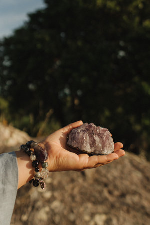 Close-up of female hands holding natural healing stones. Tools for energy balance, emotional support, self-discovery through intention, intuition, gentle presence. Vintage tone. Soft focus, blurred.の写真素材