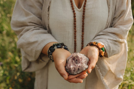Close-up of female hands holding natural healing stones. Tools for energy balance, emotional support, self-discovery through intention, intuition, gentle presence. Vintage tone. Soft focus, blurred.の写真素材