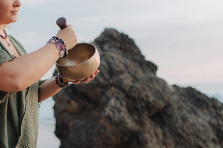Close-up of female hands holding sound healing instruments. Tools for therapy, inner balance, and self-discovery through vibration, intention, and deep presence. Vintage tone. Soft focus, blurred.の写真素材