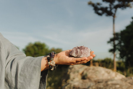 Close-up of female hands holding natural healing stones. Tools for energy balance, emotional support, self-discovery through intention, intuition, gentle presence. Vintage tone. Soft focus, blurred.の写真素材