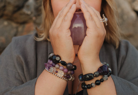 Close-up of female hands holding natural healing stones. Tools for energy balance, emotional support, self-discovery through intention, intuition, gentle presence. Vintage tone. Soft focus, blurred.の写真素材