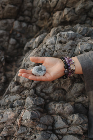 Close-up of female hands holding natural healing stones. Tools for energy balance, emotional support, self-discovery through intention, intuition, gentle presence. Vintage tone. Soft focus, blurred.の写真素材
