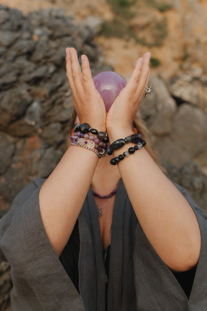 Close-up of female hands holding natural healing stones. Tools for energy balance, emotional support, self-discovery through intention, intuition, gentle presence. Vintage tone. Soft focus, blurred.の写真素材