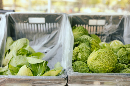 Fresh greens at small local urban market. Organic produce on sale at outdoor farmer market. Selling...