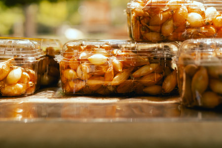 Fresh onion in plastic boxes at small local urban market. Organic produce on sale at outdoor farmer...