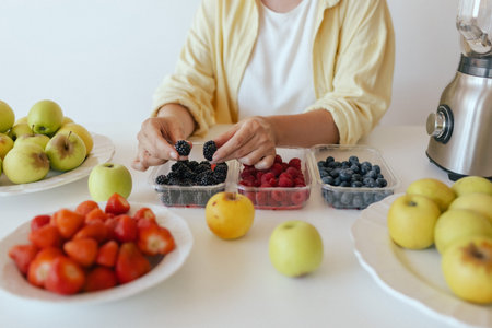Caucasian woman preparing homemade fruit leather, slicing fresh fruit in her kitchen for a healthy snack. Part of a series on organic treats and natural living.の写真素材