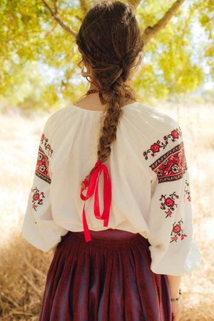 Close-up of Ukrainian traditional costume embroidered vyshyvanka blouse, woven belt kraika, folk...