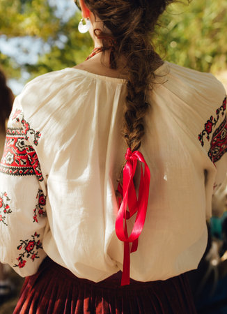Close-up of Ukrainian traditional costume embroidered vyshyvanka blouse, woven belt kraika, folk...