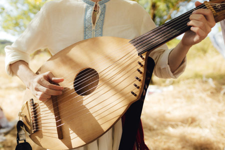 Close-up of man's hands with Ukrainian traditional musical string instrument - kobza. Folk ethnic...