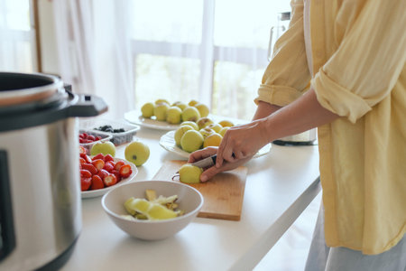 Healthy senior woman in her kitchen. Mature woman serving herself wholesome vegan food at home. Woman taking care of her aging body with a plant-based diet.の写真素材