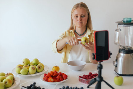 Middle-aged woman preparing homemade fruit leather, slicing fresh fruit in her kitchen for a healthy snack. Part of a series on organic treats and natural living. User-generated content.の写真素材