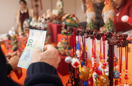 Chinese New Year market featuring traditional Asian talismans, including feng shui items, candles, dragons, lucky cats, jade ornaments, coins, souvenirs celebrating prosperity and good fortune.の写真素材