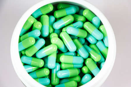 green capsules in white bottle