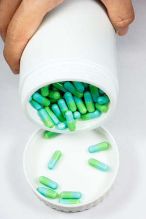 green capsules in white bottleの写真素材