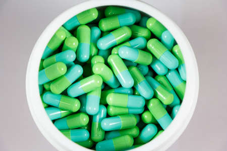 green capsules in white bottleの写真素材