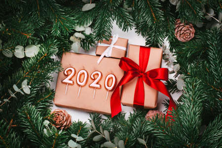 Gifts, numbers 2020 and Christmas tree branches with cones and eucalypt.