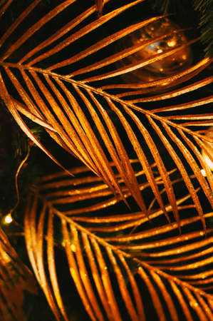 Golden tropical leaves. Bright Christmas tropical decoration.