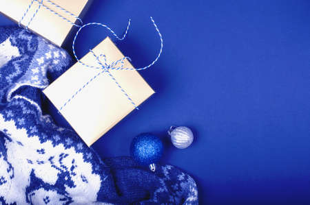 Knitted blue and white sweater with a classic pattern deer. Presents and Christmas balls on the...