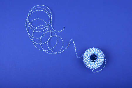 Clew of threads on the blue background.