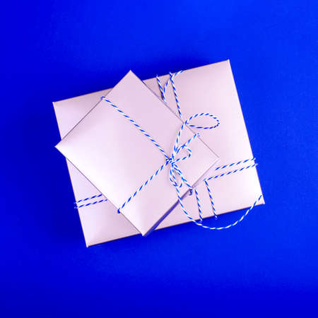 Gift boxes with white-blue threads on the bright blue background. Minimal flat lay.の写真素材