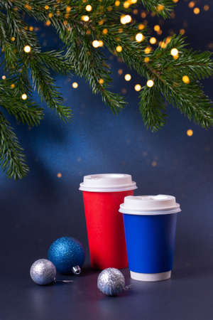 Blank blue and red to go coffee cups with Christmas decorations and pine tree with sparkles.の写真素材