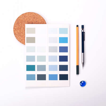Shades of trending blue color swatches on white background with stationery. Flat lay for interior...