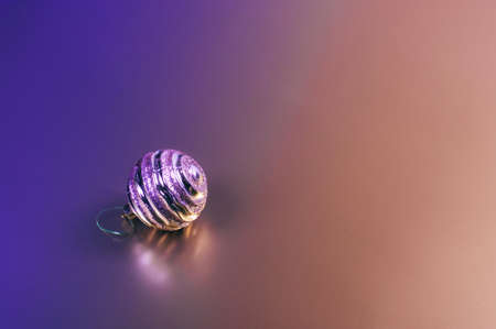 A shiny Christmas decorative ball on two colored background. Place for text.の写真素材