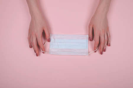 Woman hans hold madicine face mask on pink backgroundの写真素材