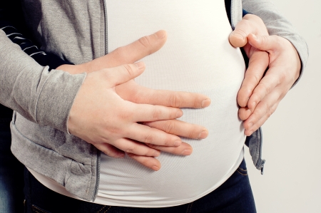 Man s hands embrace a belly of the pregnant womanの写真素材