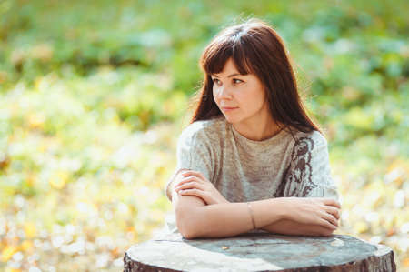 Beautiful elegant brunette woman walking in autumn parkの写真素材