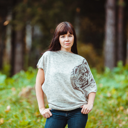 Beautiful elegant woman standing in a park in autumnの写真素材