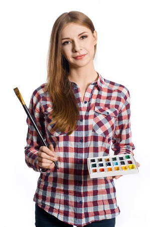 Beautiful young woman painter with brushes and palette, isolated on whiteの写真素材