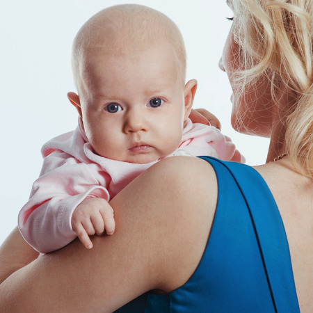 Mother holding sweet baby girl. Happy cheerful family. Closeup tender and love portraitの写真素材