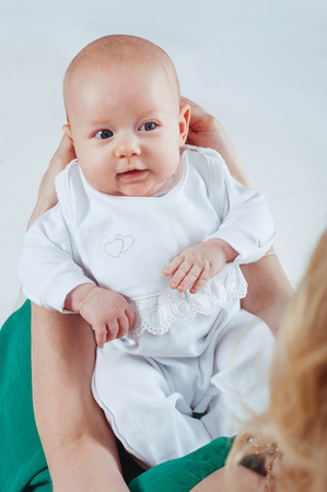 Mother holding sweet baby girl. Happy cheerful family.の写真素材